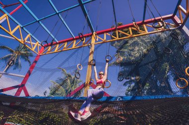 Spor kampında jimnastik yüzükleri kullanan atletik genç bir kadın..