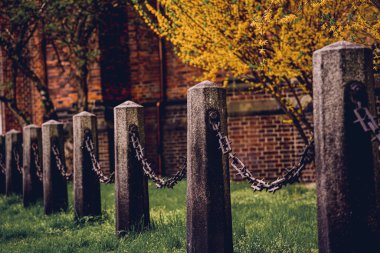 Yeşil çimenler üzerinde zincirleri olan eski taş direkler..