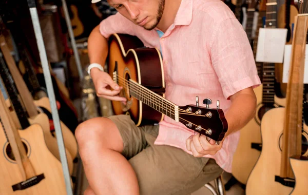 Młody Muzyk Stroi Gitarę Klasyczną Sklepie Gitarami — Zdjęcie stockowe
