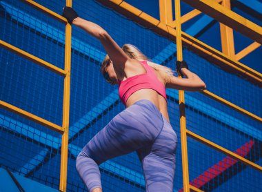 Atletik genç bayan antrenman kampında çalışıyor ve tırmanıyor.