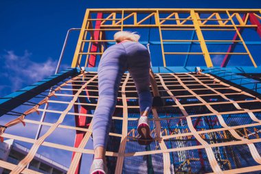 Atletik genç bayan antrenman kampında çalışıyor ve tırmanıyor.