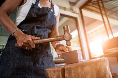 Genç bayan kuyumcu atölyede mücevher yapıyor..