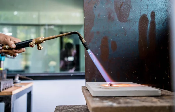 stock image Jeweler using a burner to shape a piece in a workshop.