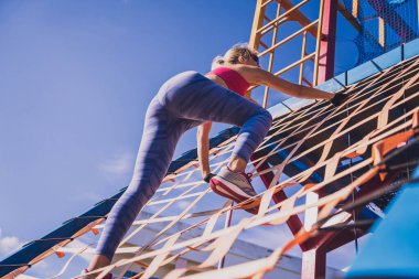 Atletik genç bayan antrenman kampında çalışıyor ve tırmanıyor.