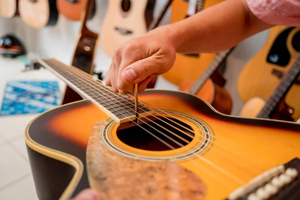 Jovem Músico Afinando Uma Guitarra Clássica Uma Loja Guitarra — Fotografia de Stock
