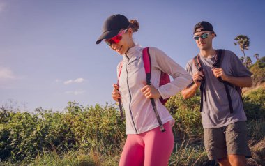 Mutlu genç çift okyanusun yakınındaki dağların zirvesine tırmanıyor..