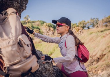 Mutlu genç çift okyanusun yakınındaki dağların zirvesine tırmanıyor..