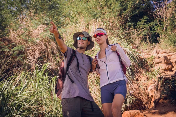 Happy young couple traveling in the jungle forest near the ocean.