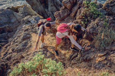 Mutlu genç çift okyanusun yakınındaki dağların zirvesine tırmanıyor..