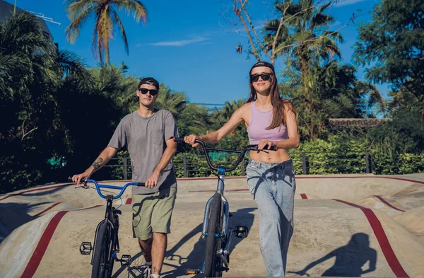 Genç mutlu çift kaykay parkında BMX 'in tadını çıkarıyor..