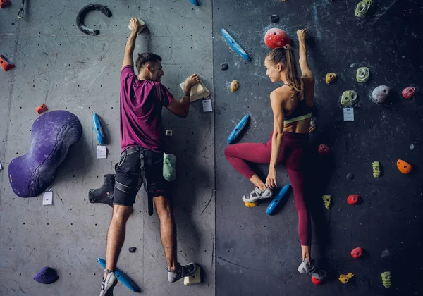 カラフルなグリップとロープで人工的な壁を登るクライマーの強いカップル — ストック写真