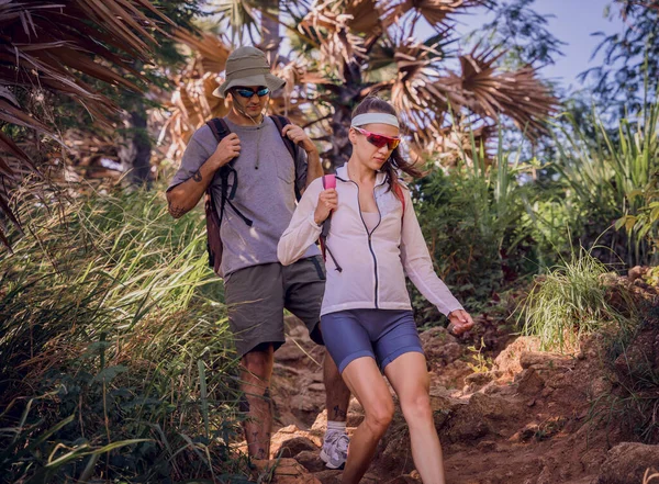 Happy young couple traveling in the jungle forest near the ocean.