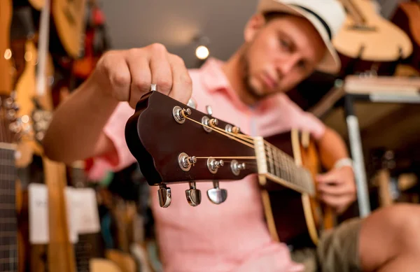 Joven Músico Afinando Una Guitarra Clásica Una Tienda Guitarra —  Fotos de Stock