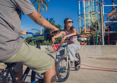 Genç mutlu çift kaykay parkında BMX 'in tadını çıkarıyor..