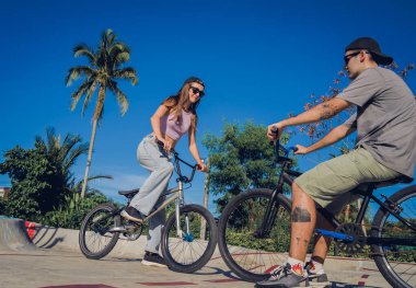 Genç mutlu çift kaykay parkında BMX 'in tadını çıkarıyor..