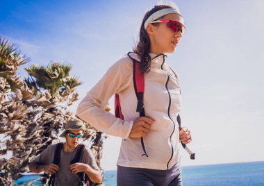 Mutlu genç çift okyanusun yakınındaki dağların zirvesine tırmanıyor..