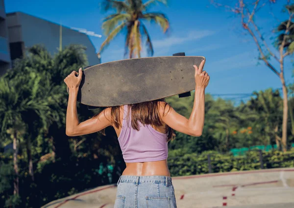 スケートボードを持つ幸せな若い女性は スケートパークでロングボードを楽しむ — ストック写真