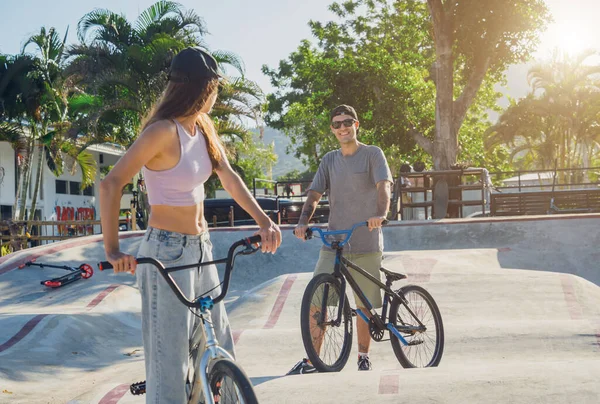 Genç mutlu çift kaykay parkında BMX 'in tadını çıkarıyor..