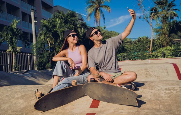 スケートパークでセルフィーを取るスケートボードを持つ若い幸せなカップル — ストック写真
