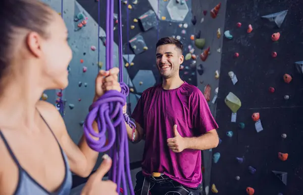 カラフルなグリップとロープを持つ人工的な壁に対する強力なカップルの登山者 — ストック写真