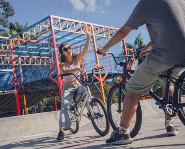 Genç mutlu çift kaykay parkında BMX 'in tadını çıkarıyor..