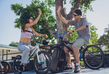 Genç mutlu çift kaykay parkında BMX 'in tadını çıkarıyor..