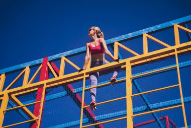 Atletik genç bayan antrenman kampında çalışıyor ve tırmanıyor.