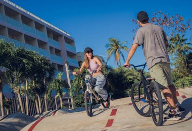 Genç mutlu çift kaykay parkında BMX 'in tadını çıkarıyor..