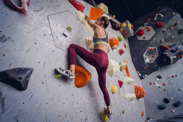 Een Sterke Vrouwelijke Klimmer Beklimt Een Kunstmatige Muur Met Kleurrijke — Stockfoto