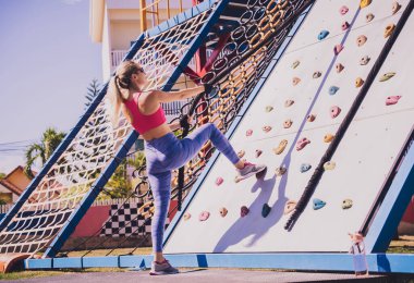 Atletik genç bayan halat kampında ip tırmanışı yapıyor.