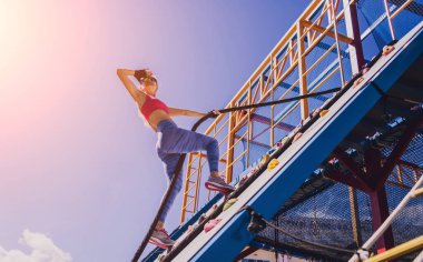 Atletik genç bayan halat kampında ip tırmanışı yapıyor.