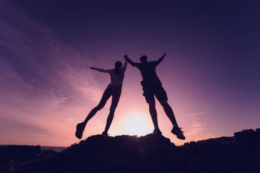 Mutlu genç çift okyanusun yakınındaki dağların zirvesine tırmanıyor..