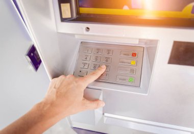Genç bir kadın ATM 'den para çekmek için kartı kullanıyor..