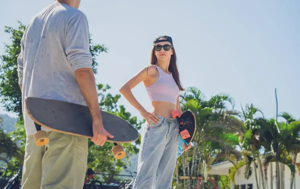 stock image Young happy couple with skateboards enjoy longboarding at the skatepark.