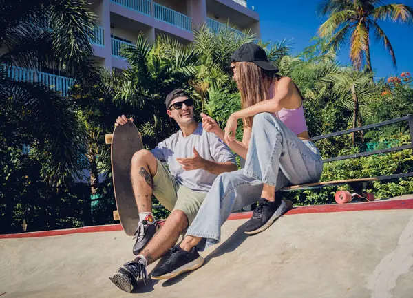 スケートボードを持つ若い幸せなカップルは スケートパークでロングボードを楽しんでいます — ストック写真