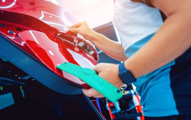 Yeni kırmızı arabaya koruyucu film yükleme işlemi