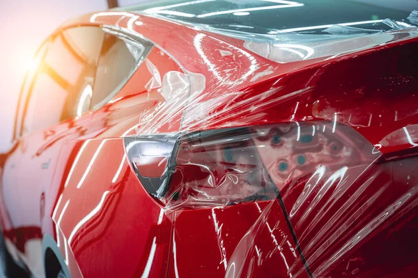 新しい赤い車に保護フィルムを取付けるプロセス — ストック写真