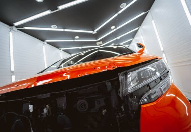 Araba servisinin garajında parçalanmış bir arabanın yedek parçalarını değiştirmek..