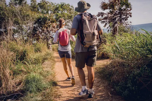 Young couple traveling in the jungle forest near the ocean.