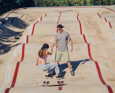 Kaykaylı genç çift kaykayın tadını çıkarıyor..
