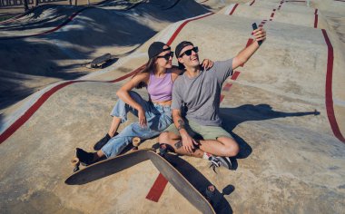 Kaykaylı genç çift kaykay parkında selfie çekiyor..