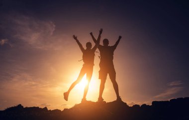 Mutlu genç çift okyanusun yakınındaki dağların zirvesine tırmanıyor..