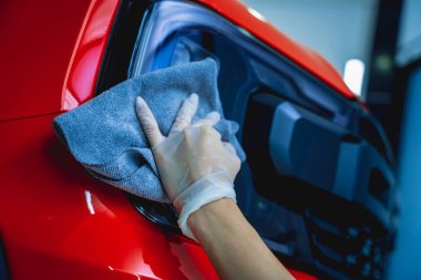 Araba temizleme işçisi mikrofiber bez ve süpürge ile araba temizleme ve cilalama