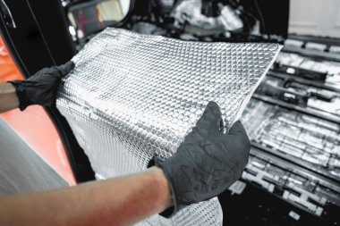 Tunning servis çalışanı arabanın içine ses yalıtımı malzemesi yükle.