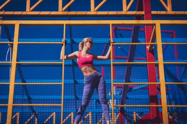 Atletik genç bayan antrenman kampında çalışıyor ve tırmanıyor.