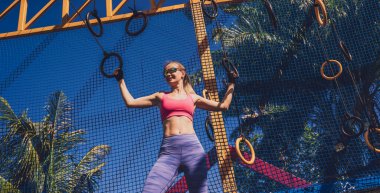 Spor kampında jimnastik yüzükleri kullanan atletik genç bir kadın..