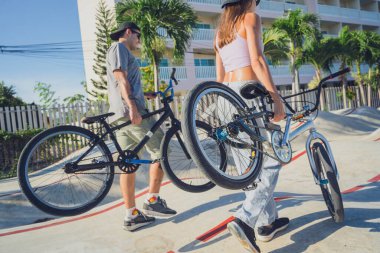 Genç mutlu çift kaykay parkında BMX 'in tadını çıkarıyor..