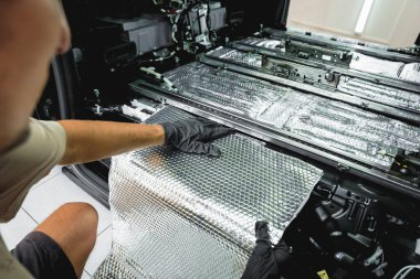 Tunning servis çalışanı arabanın içine ses yalıtımı malzemesi yükle.