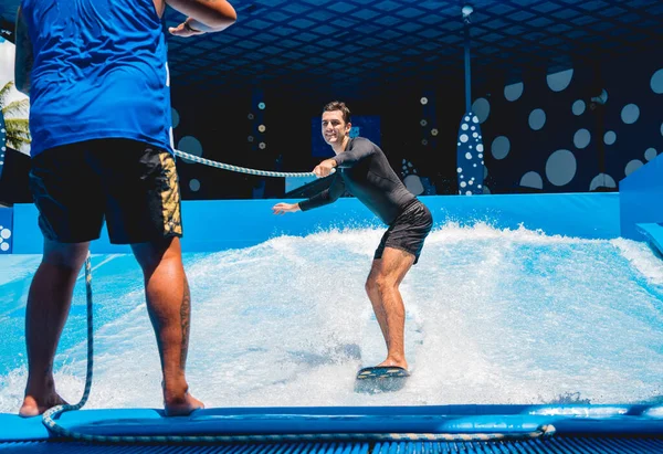 Genç Bir Adam Parkında Bir Dalga Simülatöründe Antrenörle Sörf Yapıyor — Stok fotoğraf