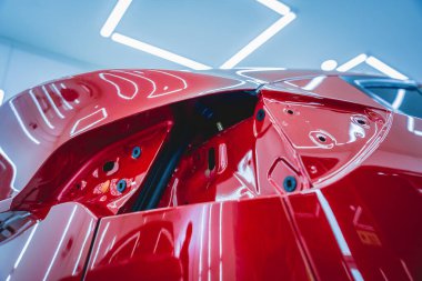 Yeni kırmızı arabaya koruyucu film yükleme işlemi